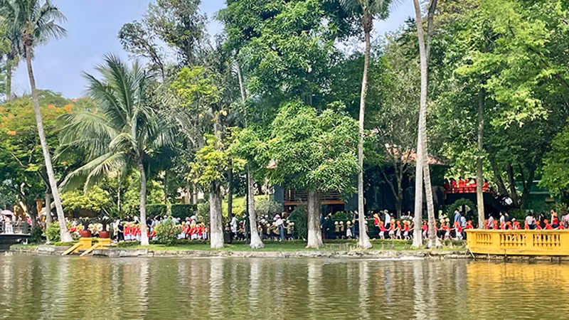 Du khách tham quan nhà sàn, ao cá Bác Hồ trong Khu Di tích Chủ tịch Hồ Chí Minh tại Phủ Chủ tịch.