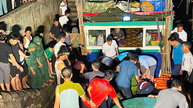 Các lực lượng chức năng và người dân khẩn trương đưa nạn nhân lên bờ.