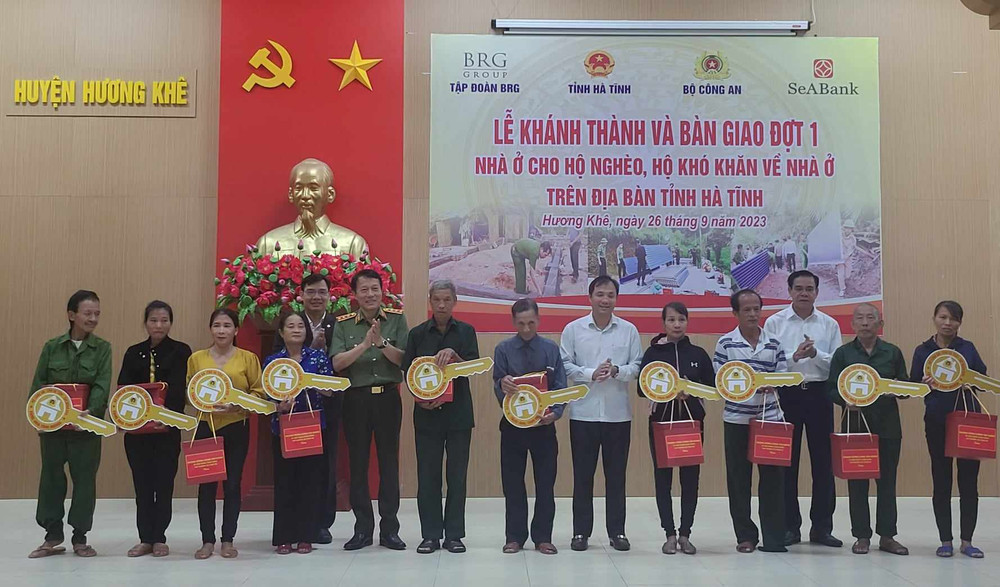 Các đồng chí lãnh đạo Bộ Công an và tỉnh Hà Tĩnh trao quà và chìa khóa tượng trưng cho các hộ dân.