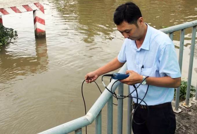Cán bộ nông nghiệp kiểm tra độ mặn trên kênh tại Bạc Liêu. Ảnh: Cửu Long