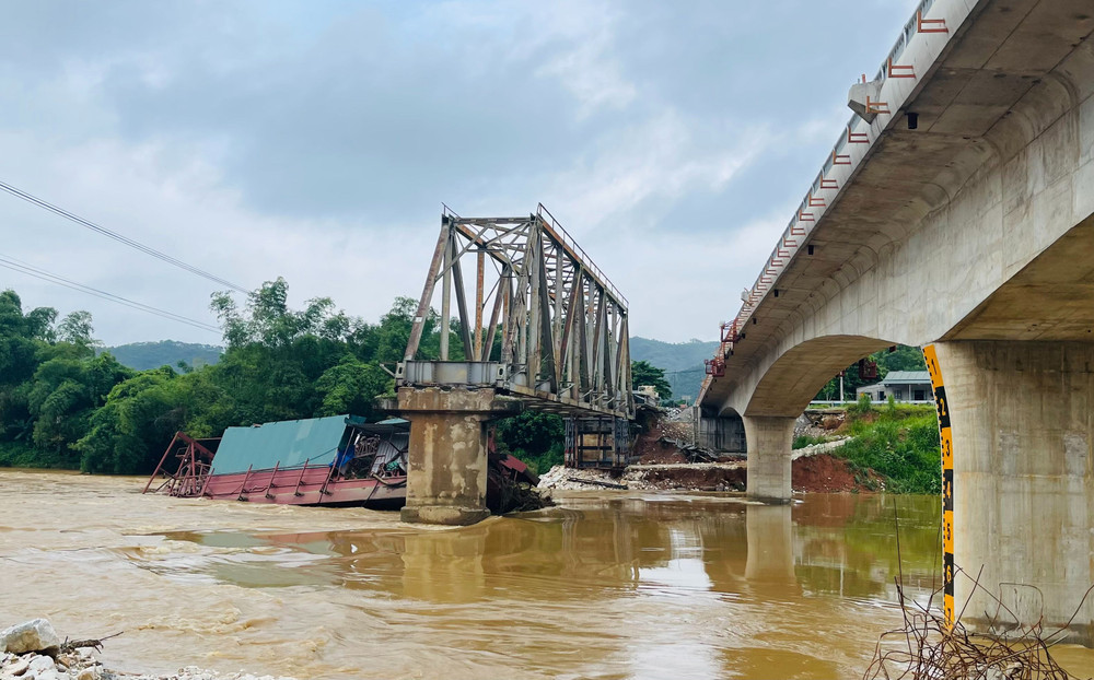 Chiếc tàu cuốc bị mắc kẹt vào trụ cầu Tô Mậu cũ đang trong quá trình tháo dỡ. (Ảnh: THANH SƠN)