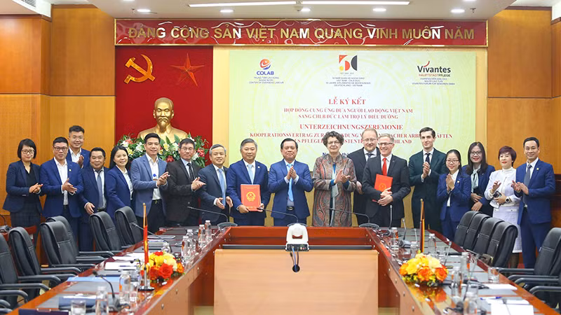 Thứ trưởng Nội vụ Nguyễn Bá Hoan và Đại sứ CHLB Đức tại Việt Nam Helga Margarete Barth cùng chứng kiến lễ ký kết hợp đồng giữa hai đơn vị. (Ảnh Moha)