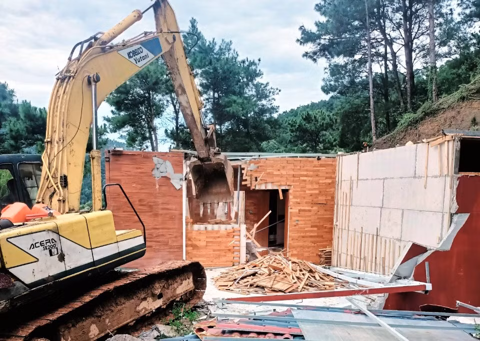 Lực lượng chức năng phá dỡ công trình vi phạm đất rừng, trật tự xây dựng.