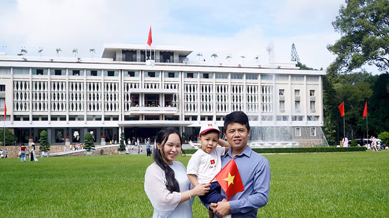 Nhiều gia đình mặc áo dài khi đi tham quan và chụp ảnh trước cửa Dinh Độc Lập.