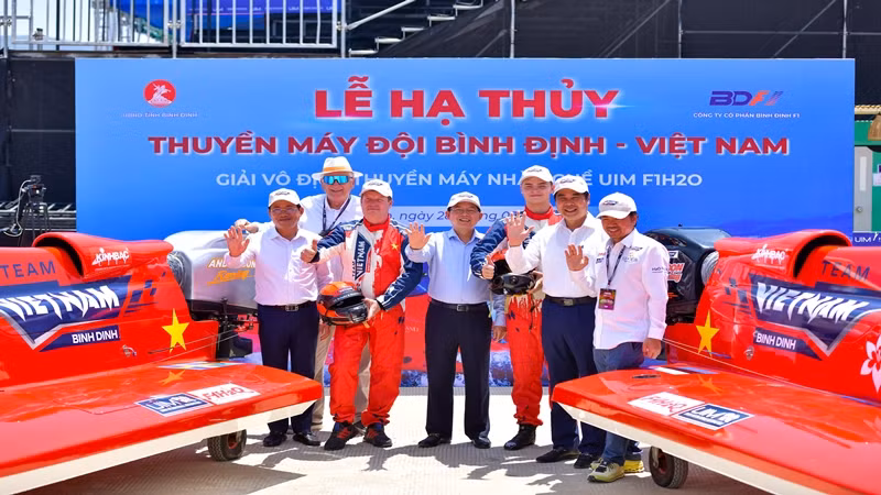 Các đại biểu chụp ảnh lưu niệm trước khi hạ thủy hai chiếc thuyền.