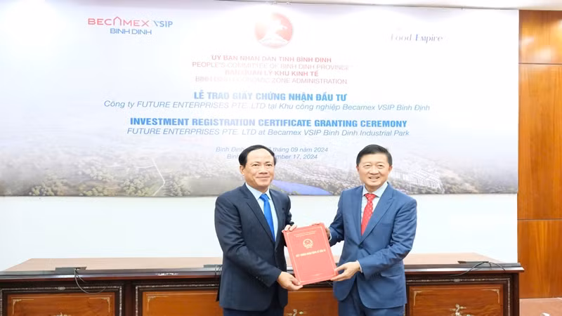 Chủ tịch Ủy ban nhân dân tỉnh Bình Định Phạm Anh Tuấn (trái) trao Giấy Chứng nhận đăng ký đầu tư cho ông Tang Wang Cheow, Chủ tịch Tập đoàn Food Empire.