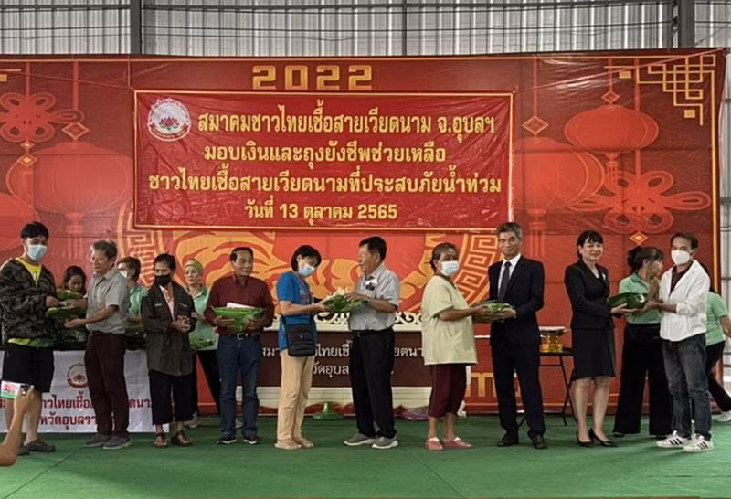 Tổng Lãnh sự Chu Đức Dũng và đại diện Hội người Thái gốc Việt trao quà cho bà con kiều bào.