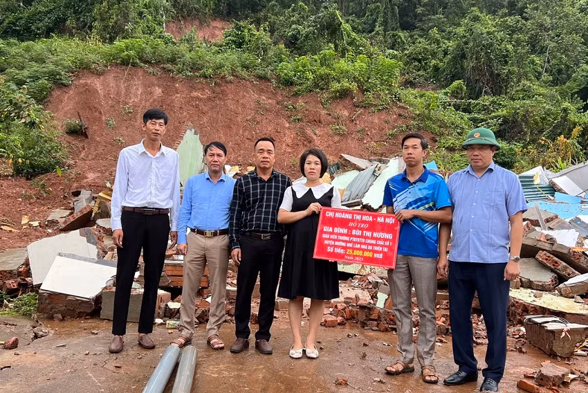 Đại diện Báo Giáo dục và thời đại cũng lãnh đạo huyện Mường Nhé trao tiền hỗ trợ gia đình cô giáo Bùi Thị Hương.