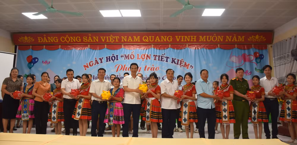 Các đồng chí lãnh đạo huyện Nậm Pồ và học sinh trong huyện hưởng ứng phong trào nuôi lợn đất ủng hộ cho giáo dục. 