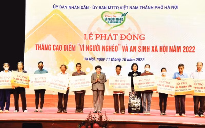 Lãnh đạo thành phố trao hỗ trợ sinh kế cho người nghèo, người khó khăn tại Lễ phát động Tháng cao điểm "Vì người nghèo" và an sinh xã hội năm 2022. (Ảnh THÀNH NGUYỄN)