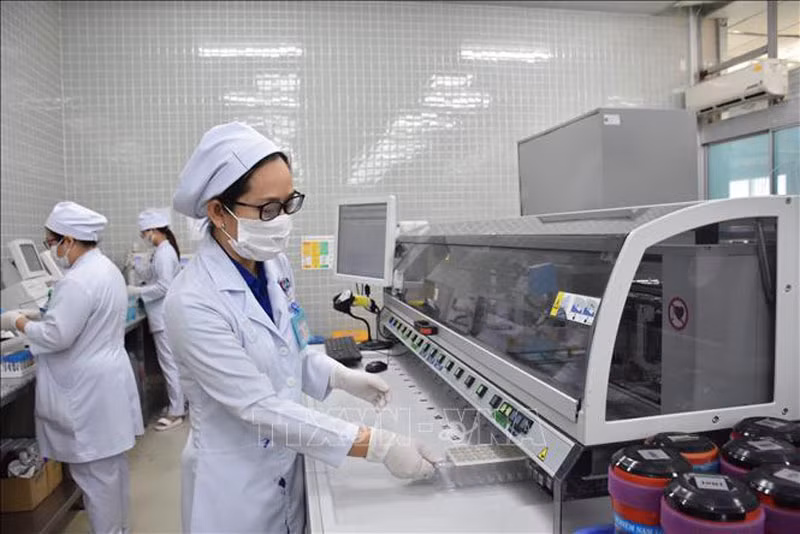 Nhân viên y tế Bệnh viện Chợ Rẫy vận hành hệ thống máy xét nghiệm.