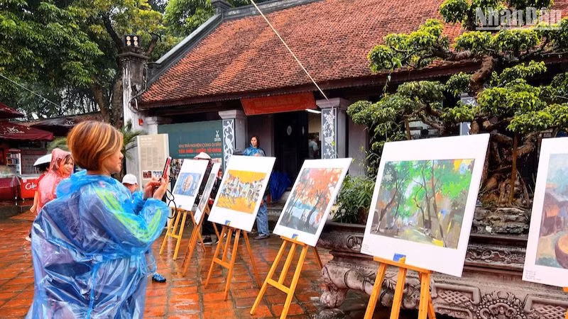 Khách tham quan thưởng lãm các tác phẩm hội họa và nhiếp ảnh đặc sắc.