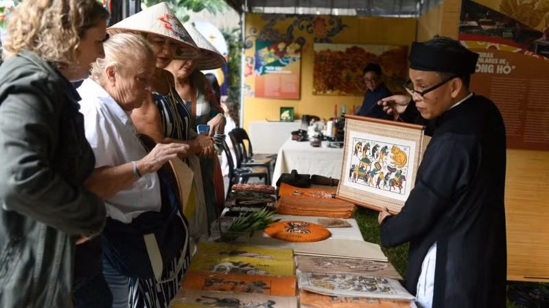 Nghệ nhân Nguyễn Đăng Tâm giới thiệu tranh dân gian Đông Hồ tới bạn bè quốc tế. (ẢNH: BTC)