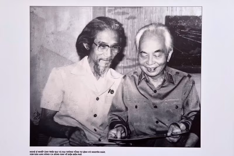 Nghệ sĩ nhiếp ảnh Triệu Đại và Đại tướng Võ Nguyên Giáp xem lại những bức ảnh chụp Điện Biên Phủ.