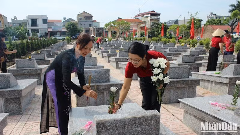 Cùng quê tại xã Hà Thanh, bà Nguyễn Thị Phượng (bên phải), Phó Tổng Giám đốc Ngân hàng Nông nghiệp và Phát triển nông thôn Việt Nam và bà Hà Kim Chi (bên trái), nguyên Trưởng Ban Kiểm tra - Hội Nhà báo Việt Nam dâng hương, dâng hoa tri ân các liệt sĩ.