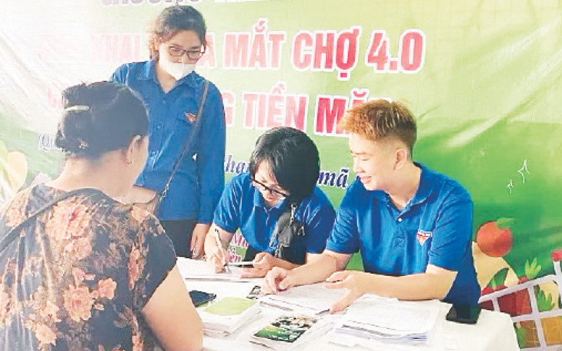 Đoàn viên thanh niên hướng dẫn tiểu thương mở tài khoản và cách thanh toán không dùng tiền mặt.