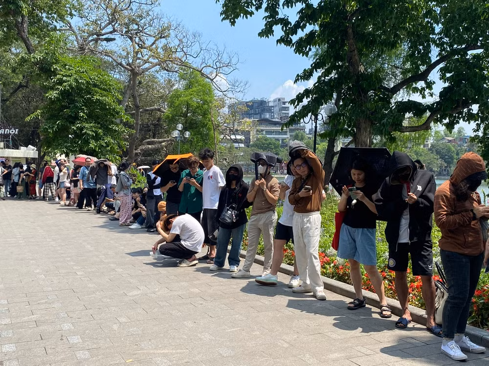 Đến 11 giờ trưa ngày 2/5, dòng người vẫn "đội nắng" xếp hàng để nhận phụ san của Báo Nhân Dân. (Ảnh: ĐỖ THOA)