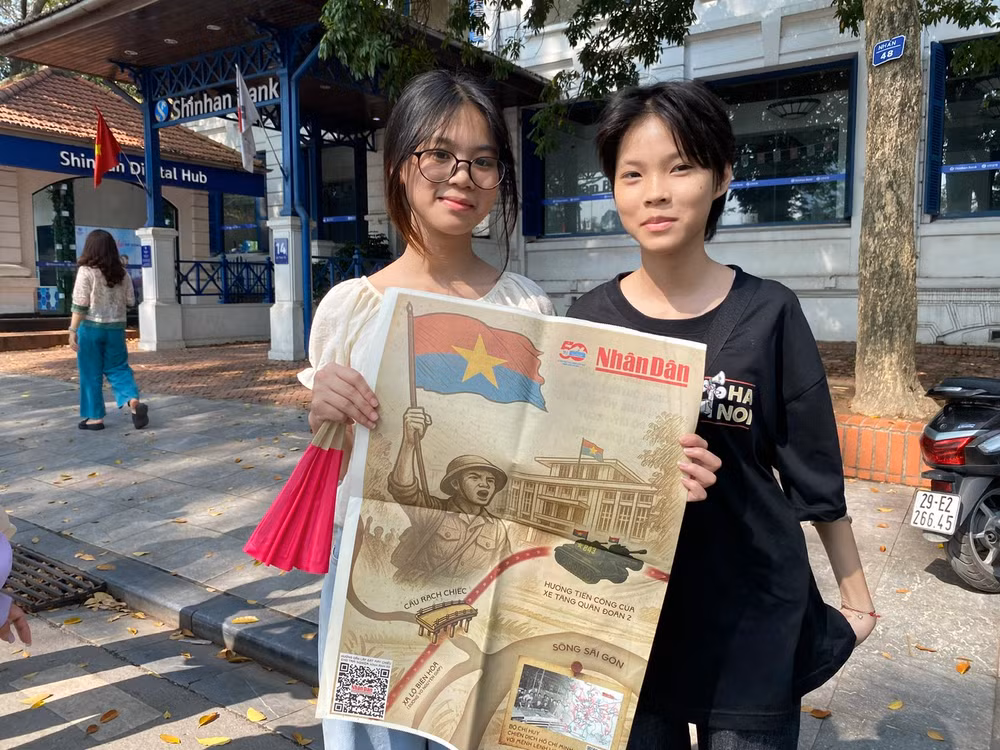 Hai bạn trẻ Nguyễn Gia Linh và Nguyễn Ngọc Diệp, học sinh lớp 9A7, Trường THCS Phúc Diễn, Bắc Từ Liêm, Hà Nội đến từ rất sớm nhận phụ san của Báo Nhân Dân và tham quan trải nghiệm triển lãm. (Ảnh: ĐỖ THOA)