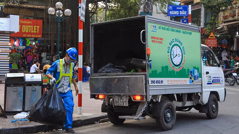Công nhân Công ty Môi trường đô thị Hà Nội thu gom rác thải trên địa bàn quận Hoàn Kiếm. (Ảnh PHẠM HÙNG)