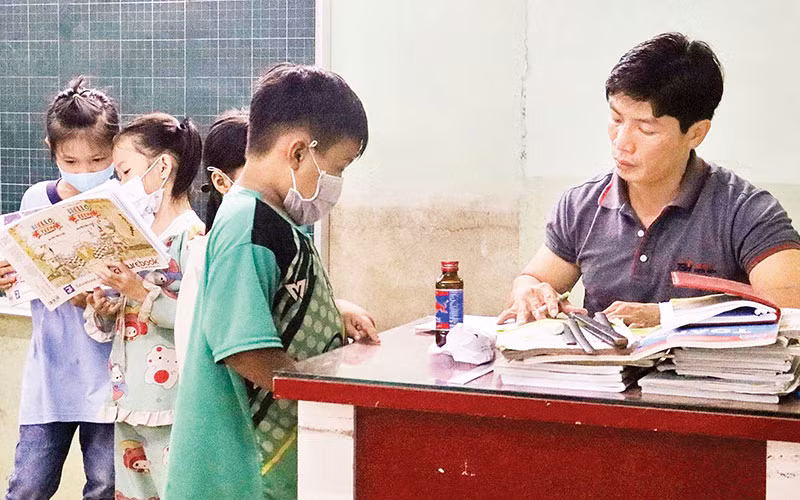 Anh Trần Lâm Thắng kiểm tra bài từng học sinh để không em nào bị hổng kiến thức.