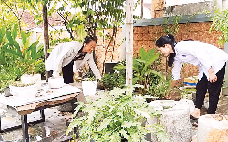 Cán bộ các trạm y tế hướng dẫn người dân vệ sinh môi trường tại hộ gia đình.