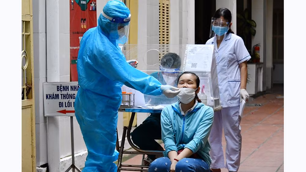 Cán bộ y tế lấy mẫu xét nghiệm cho người dân tại Hà Nội trong những ngày dịch Covid-19 diễn biến phức tạp. (Ảnh MỸ HÀ)