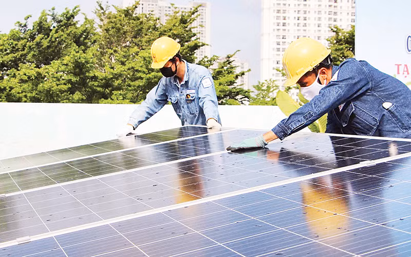 Công nhân lắp đặt hệ thống năng lượng điện mặt trời áp mái ở thành phố Thủ Đức.