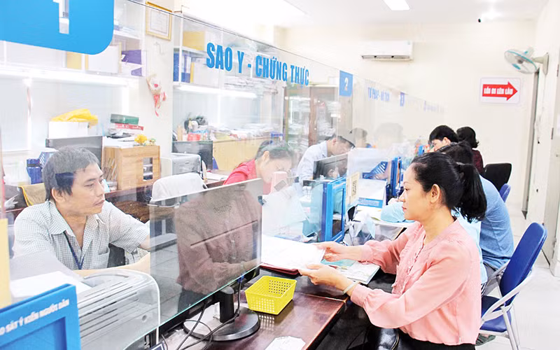 Người dân làm thủ tục hành chính tại phường Cầu Kho, Quận 1 (Ảnh THẾ ANH)