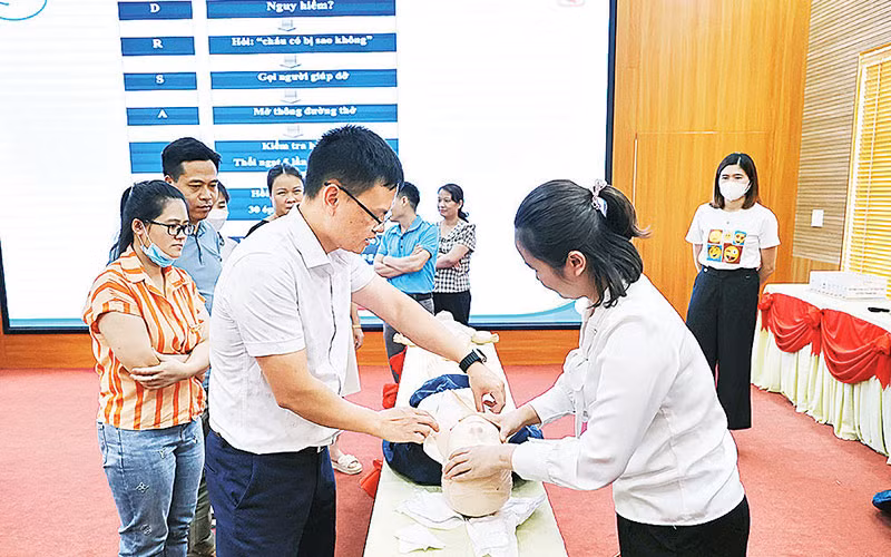 Bác sĩ của Bệnh viện Nhi Trung ương hướng dẫn thực hành sơ cấp cứu khi gặp tai nạn thương tích cho các học viên. (Ảnh PHƯƠNG THANH)