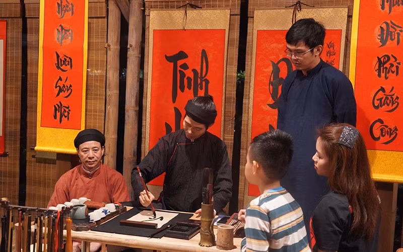 Khách du lịch xin chữ khi tham gia tour đêm tại Văn Miếu - Quốc Tử Giám.