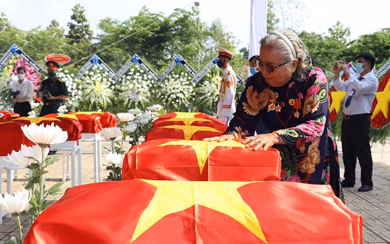 Bà Thân Thị Vân xúc động bên hài cốt đồng đội trong lễ truy điệu tại Nghĩa trang liệt sĩ huyện Nhơn Trạch (Đồng Nai).