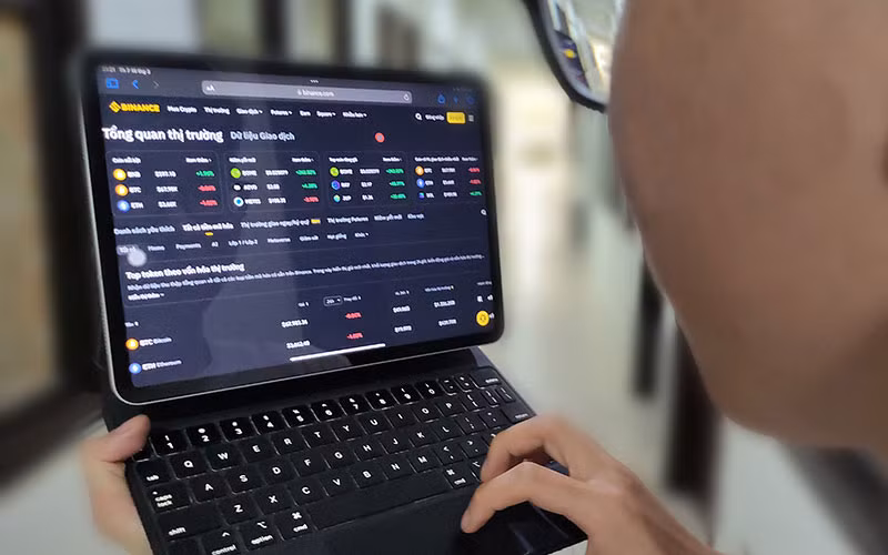 Khách hàng theo dõi tiền ảo trên sàn giao dịch tiền điện tử Binance. (Ảnh ĐĂNG ANH)