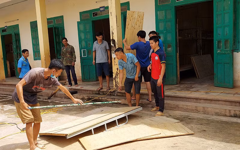 Phụ huynh, giáo viên Trường phổ thông dân tộc bán trú THCS Mường Nhé sửa chữa giường cho học sinh bán trú.