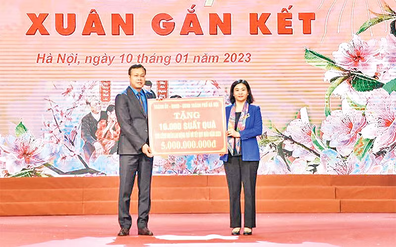 Phó Bí thư Thường trực Thành ủy Nguyễn Thị Tuyến trao quà và vé xe về quê đón Tết cho công nhân lao động. (Ảnh THANH HẢI) 