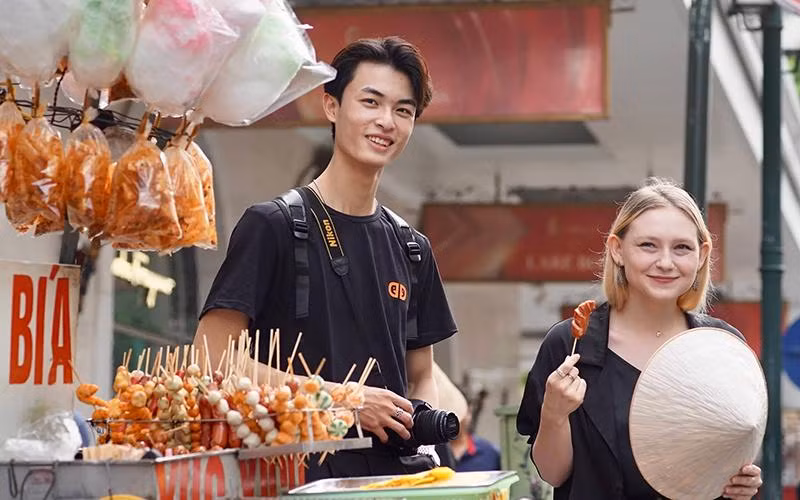 Buddy Phạm Hoàng Vũ đồng hành với du khách Australia khám phá Hà Nội. (Ảnh Thảo Phương)