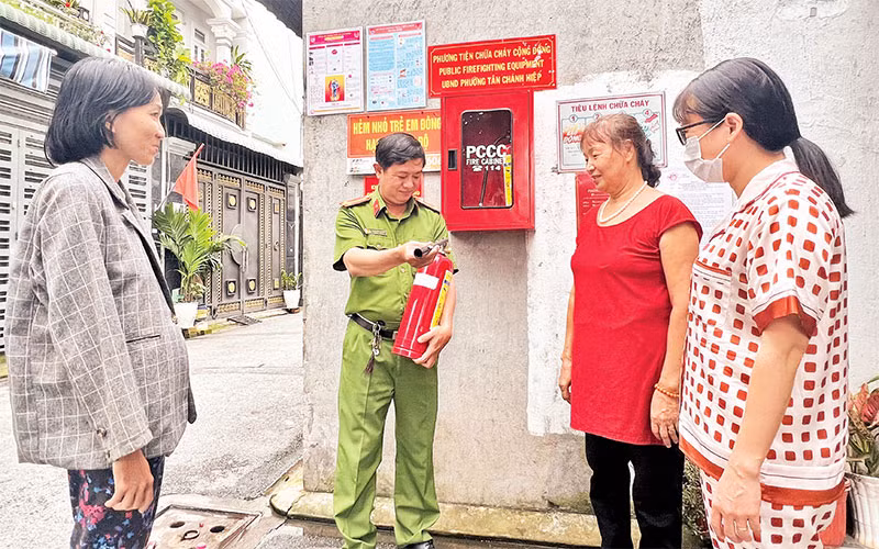 Công an khu vực phường Tân Chánh Hiệp (Quận 12) hướng dẫn người dân sử dụng bình chữa cháy.