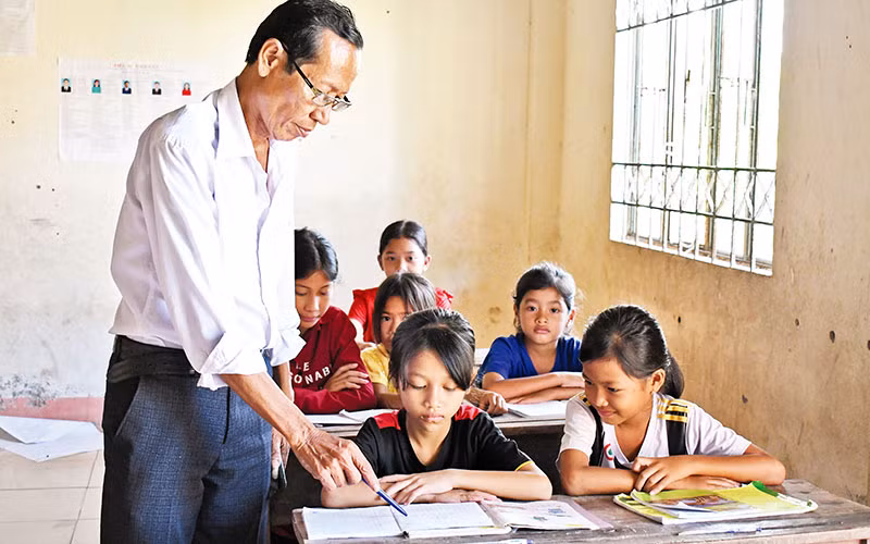 Ông Danh Nghe dạy chữ cho trẻ em dân tộc Khmer. 