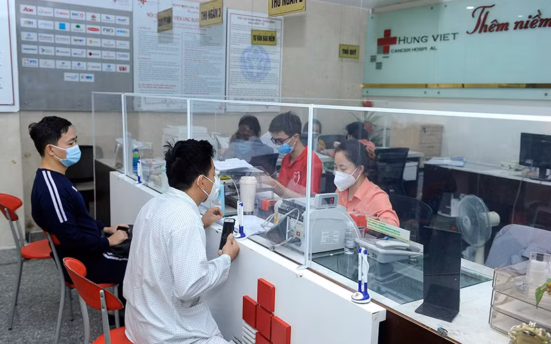 Bệnh nhân và người nhà làm thủ tục thanh toán bảo hiểm y tế tại Bệnh viện Ung bướu Hưng Việt (Hà Nội). (Ảnh NGUYỄN ĐĂNG) 