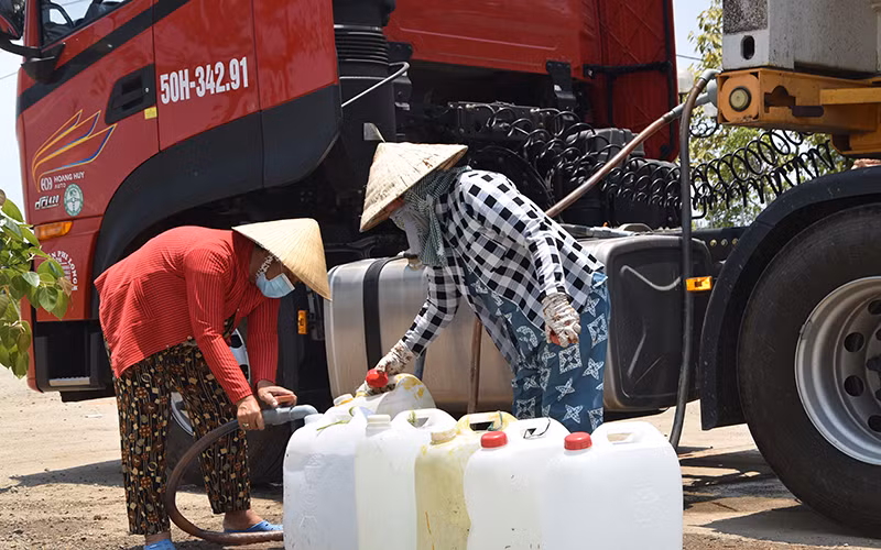 Người dân xã Gia Thuận, huyện Gò Công Đông (Tiền Giang) lấy nước miễn phí về sử dụng cho gia đình.