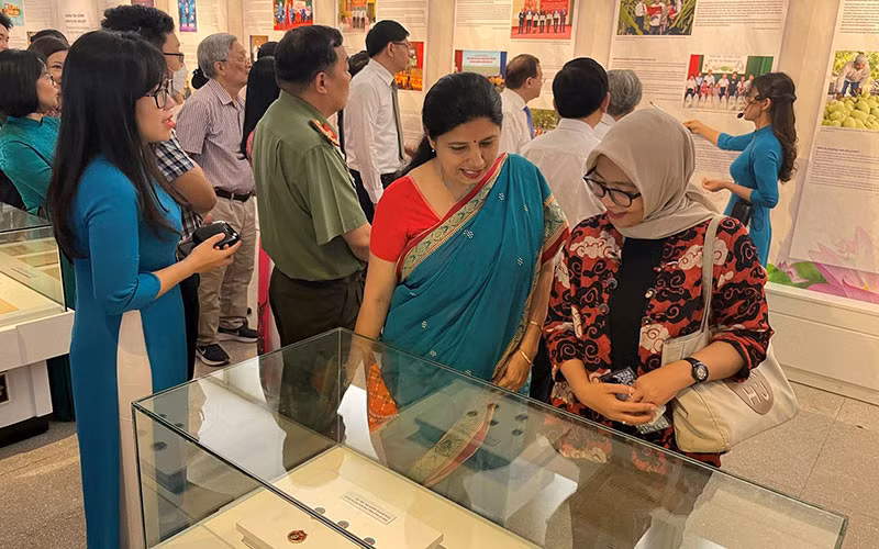 Các đại biểu, du khách tham quan không gian Triển lãm “Những tấm gương bình dị mà cao quý”. (Ảnh NGUYỄN THANH)