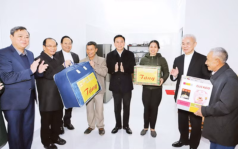 Đại diện tổ chức tôn giáo cùng lãnh đạo tỉnh Thanh Hóa trao tặng đồ dùng thiết yếu cho các hộ sinh sống trên sông lên bờ cư trú ổn định. (Ảnh MAI LUẬN)