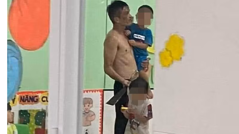 Người đàn ông khống chế các bé.