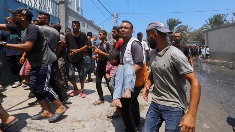 Chuyển em nhỏ bị thương sau cuộc không kích của Israel nhằm vào bệnh viện dã chiến trong trường học ở Deir al-Balah, Dải Gaza. (Ảnh: THX/TTXVN)