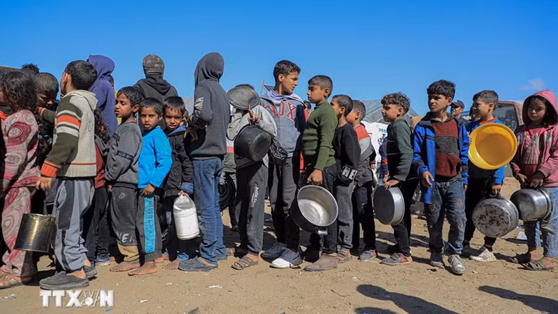 Người dân xếp hàng nhận thức ăn cứu trợ từ UNRWA tại thành phố Rafah, Dải Gaza. (Ảnh: THX/TTXVN)