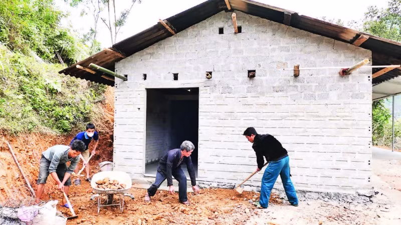 Người dân thôn Minh Phong, xã Thuận Hòa, huyện Vị Xuyên (tỉnh Hà Giang) giúp gia đình anh Sùng Ngọc Sai làm nhà mới.