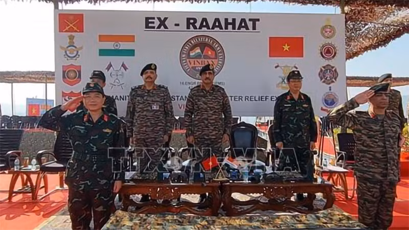 Các chỉ huy, quan chức cấp cao hai nước thực hiện nghi lễ chào cờ. (Ảnh: TTXVN)