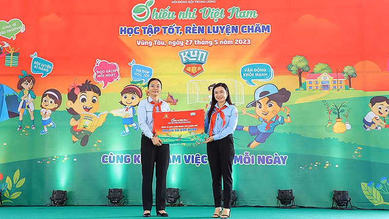 Đồng chí Nguyễn Phạm Duy Trang, Bí thư Trung ương Đoàn, Chủ tịch Hội đồng Đội Trung ương (bên phải) trao biển tượng trưng công trình "Không gian vui chơi và đọc sách cho em" tặng đại diện Hội đồng Đội tỉnh Bà Rịa-Vũng Tàu. 