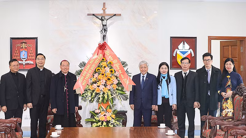 Đồng chí Đỗ Văn Chiến (thứ 5 từ phải sang) tặng hoa chúc mừng Tổng Giám mục Giuse Vũ Văn Thiên (thứ 3 từ trái sang).