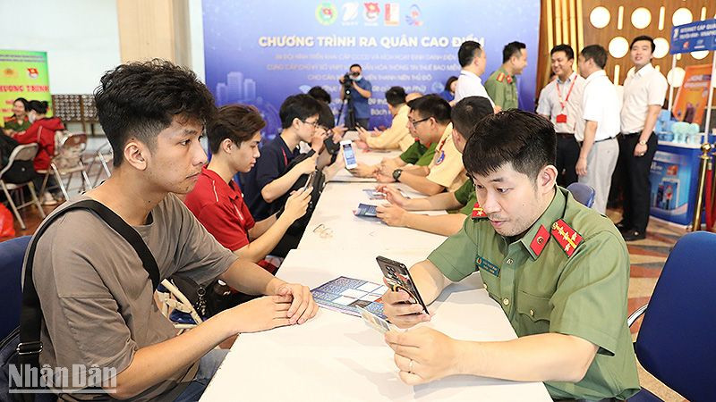 Chiến sĩ trẻ lực lượng công an thành phố Hà Nội hỗ trợ người dân kích hoạt định danh điện tử tại chương trình ra quân.