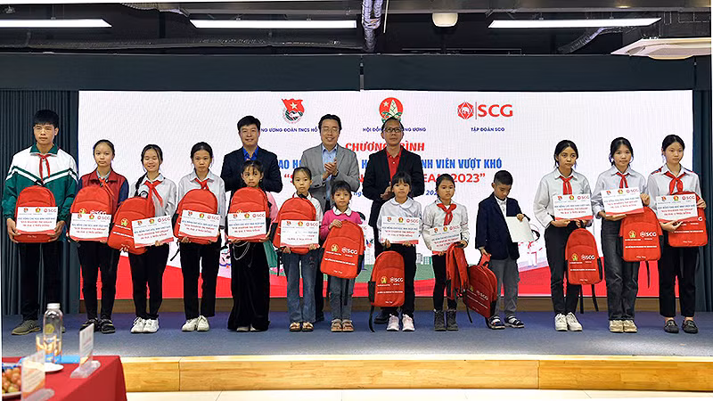 Đại diện Ban tổ chức và các bộ, ngành liên quan trao học bổng tặng học sinh có hoàn cảnh khó khăn tại chương trình. 